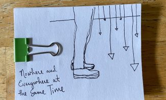 A drawing of legs standing before a series of hanging pendulums on a white index card with a green binder clip.