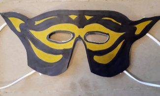 A black and yellow costume mask made from paper