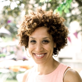 Smiling woman with short curly hair and hoop earrings
