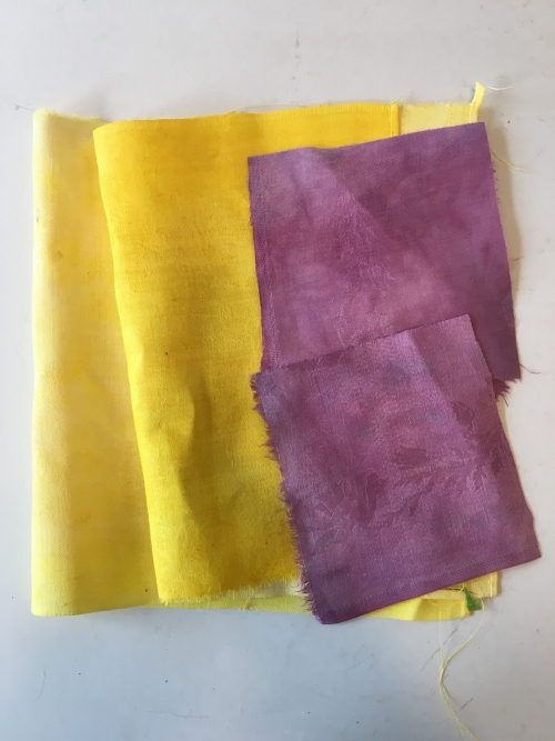 Two pieces of beautifully-colored fabric in yellow and purple.