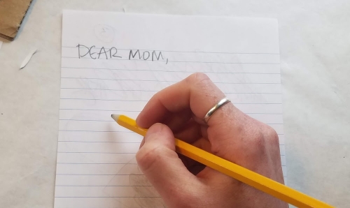 A pencil in hand with the words 