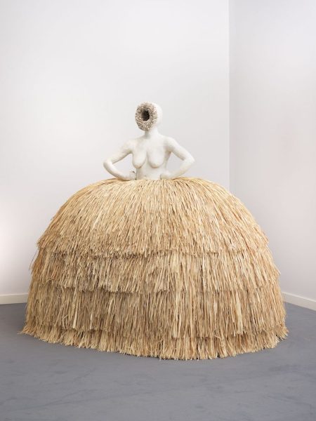 A sculpture by Simone Leigh of a woman with a raffia skirt. 