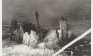 A blurry black-and-white photograph of people on a boat with small, white annotations.