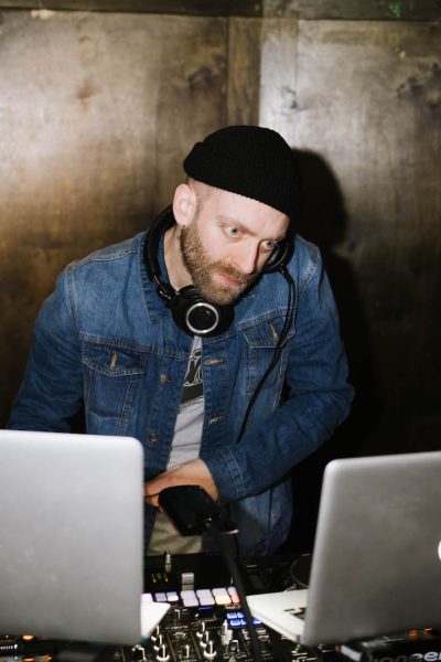 DJ Knife looking at his laptop monitor while he listens on his headphones.