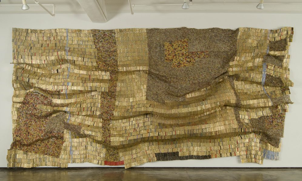 Large gold-colored woven tapestry made out of metal pieces