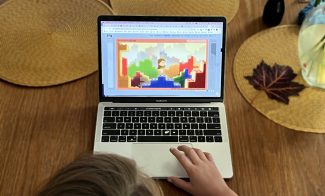 A young person watching an animated video on a laptop