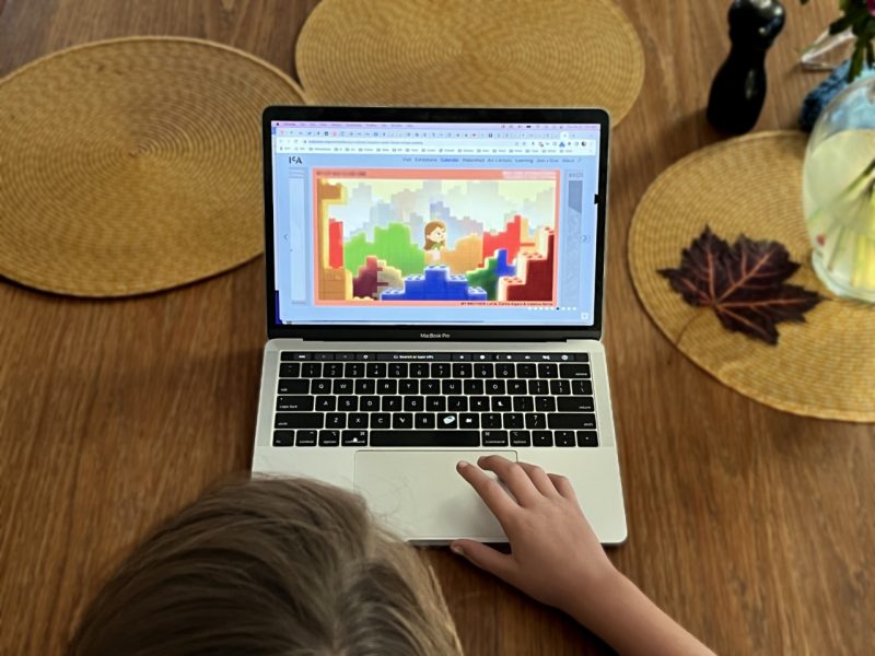 A young person watching an animated video on a laptop