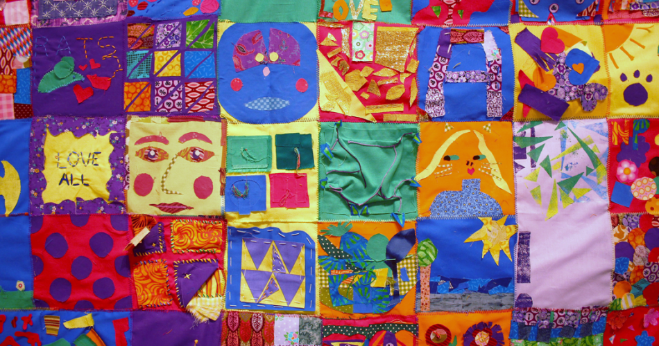 A sewn tapestry with various and colorful quilt squares.