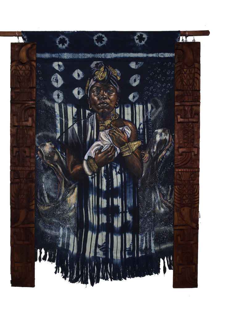 A painting on indigo-dyed fabric depicts a woman holding an infant as she looks directly at the viewer. It is flanked by carved wooden pieces.