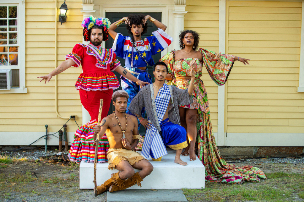 A group of people posed in brightly patterned outfits on a doorstep