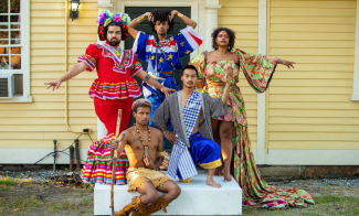 A group of people posed in brightly patterned outfits on a doorstep