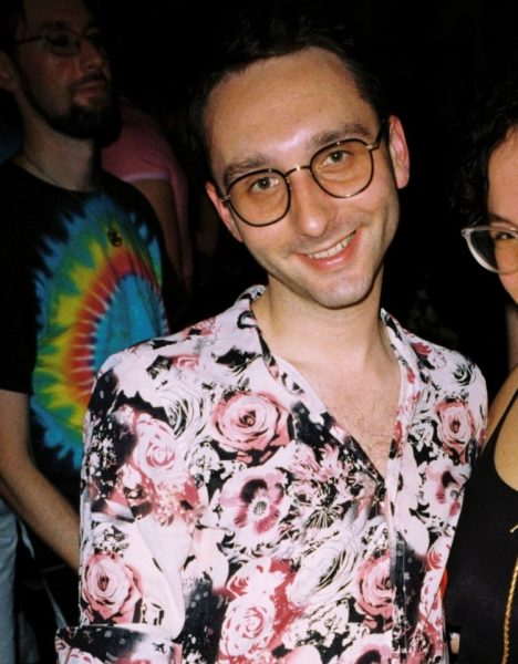 Photo of a man wearing glasses and a light pink floral shirt