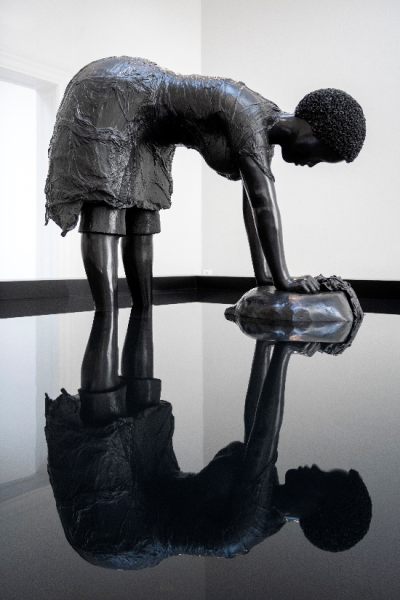 Bronze sculpture of a woman bending over