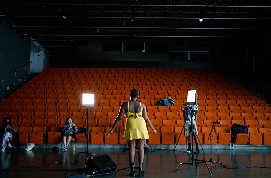 A large theater with studio lights and a performer in the center