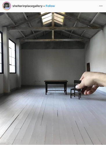 Instagram image of a hand placing miniature furniture in a realistic-looking gallery space