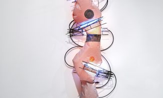 A wall sculpture composed of soft pink nylon, rebar, and lit neon lights and electrical cord.