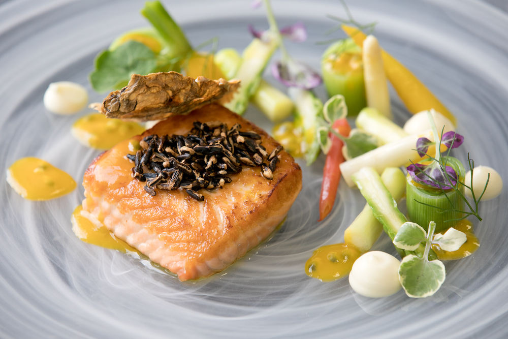 A salmon dish on a swirled glass plate