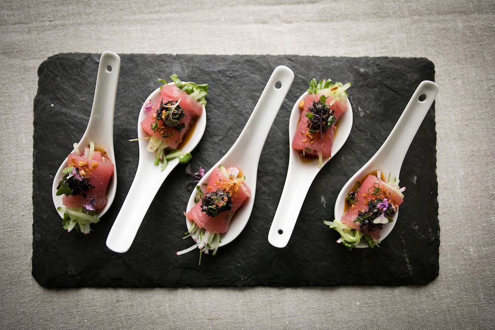 Hors d'oeuvres in white ceramic spoons arrayed on a slate