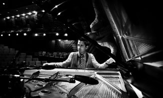 Black and white photo of musician Vijay Iver playing piano