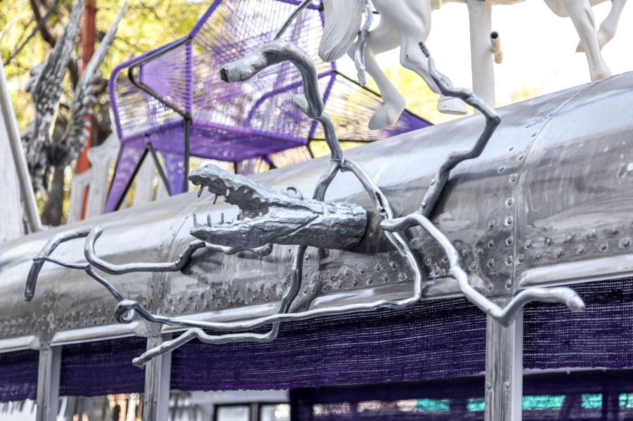 Image of a metal creature connected to the top of a metal bus.