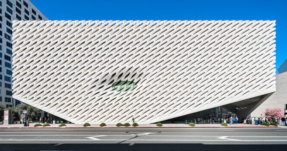 Photo of a contemporary white building with a perforated exterior against a blue sky.