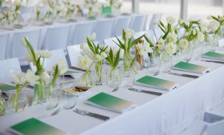 Long white tables with white tulip centerpieces