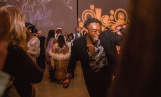 Person in snazzy brown outfit dancing in crowd