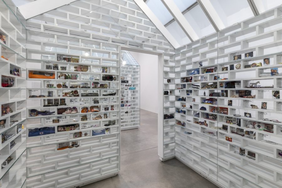 Interior view of a white house-shaped structure with objects housed in the walls