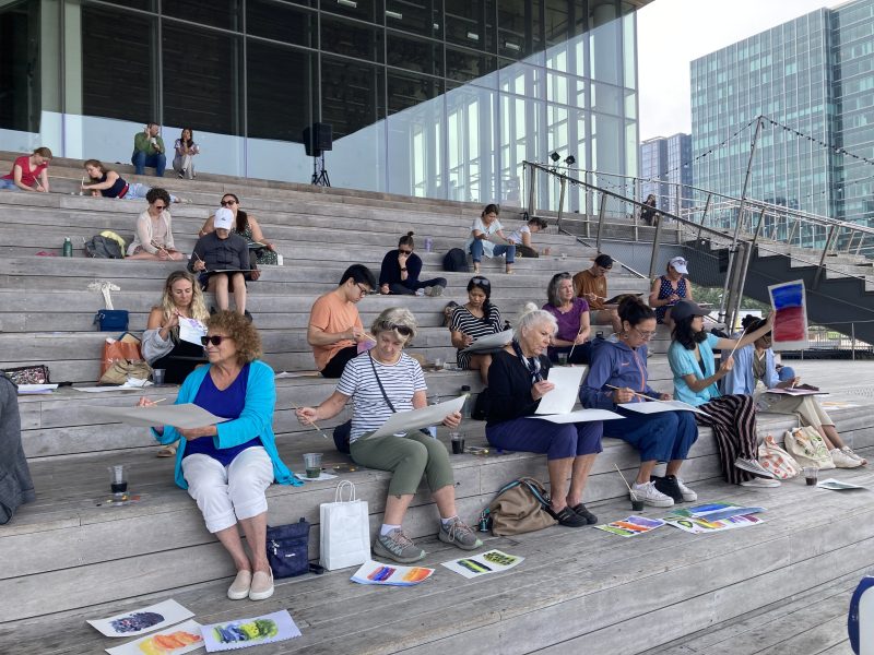 People painting outside on the ICA grandstand