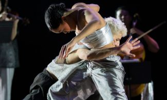 Two people in white dancing expressively