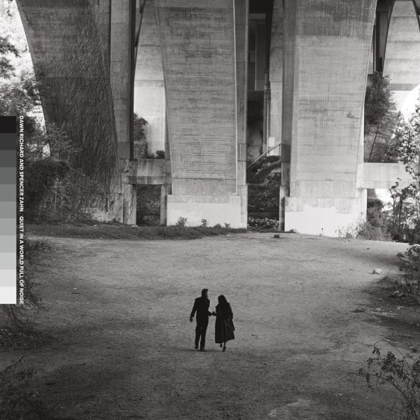 Black and white photo of two people in distance under a bridge with a grayscale on side