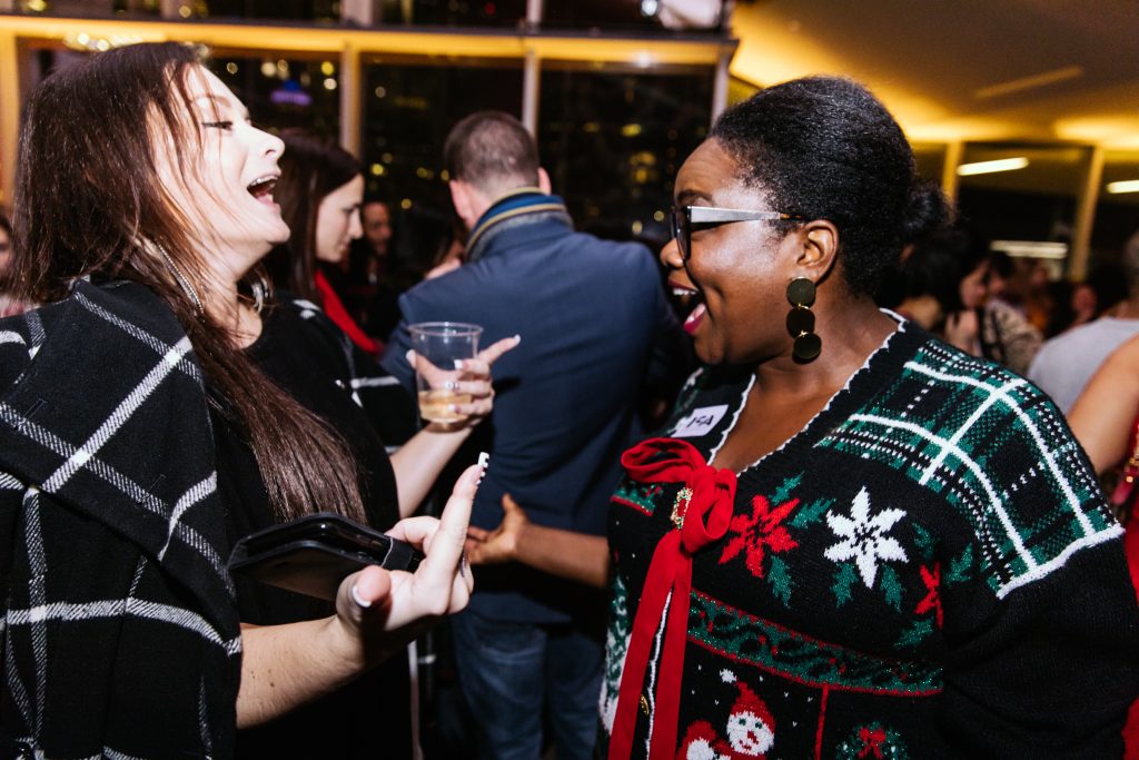 Two people in winter sweaters talking at an event