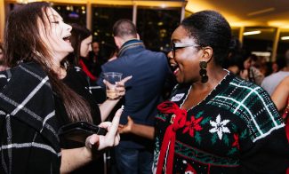 Two people in winter sweaters talking at an event