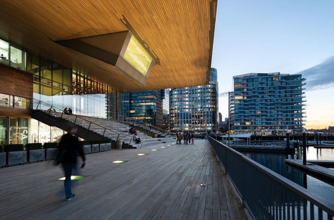 The plaza behind the ICA, with wooden planking, a grandstand, and a small windowed room hanging down from a cantilever.