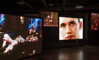 Many screens showing different videos simultaneously in a dark gallery