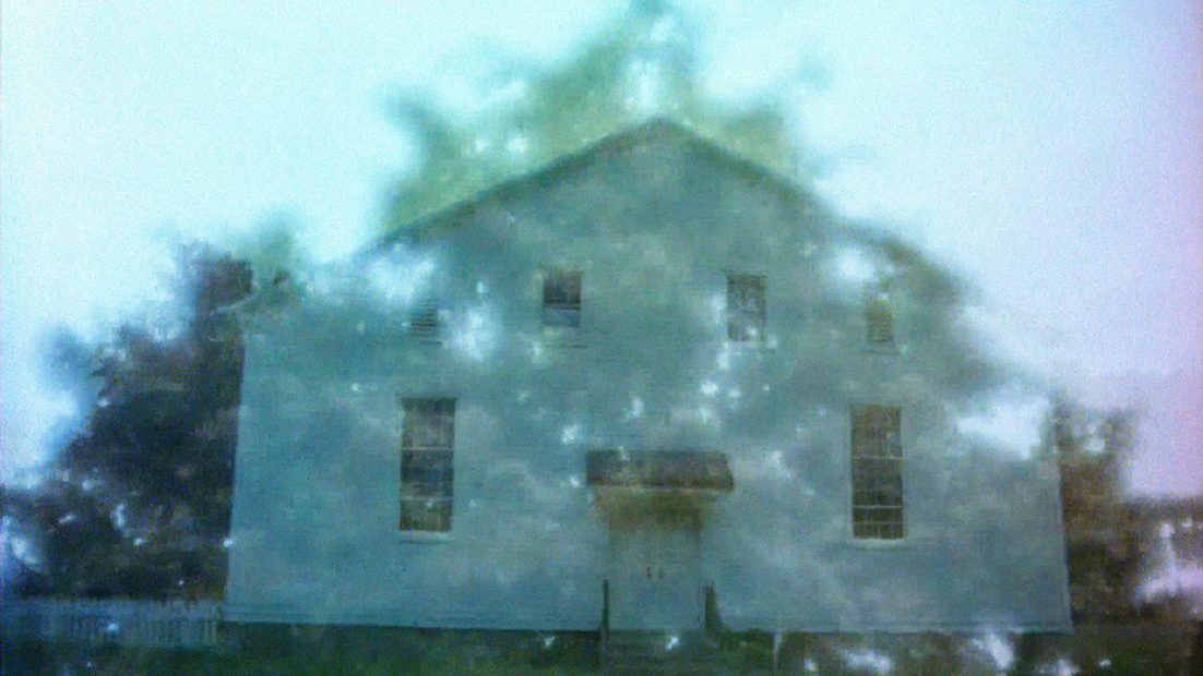 A manipulated photo of a simple house seemingly overlaying a photo of a tree.